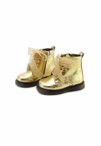 Botines metálicos dorados con un acabado texturizado, que presentan cordones de satén y un cierre lateral, sobre una suela de goma negra.