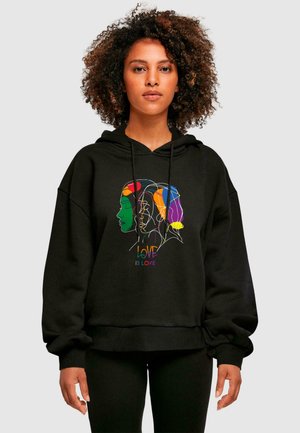Black hoodie with a loose fit, featuring a colorful line-drawn design of faces and the text "LOVE IS LOVE" in rainbow hues.