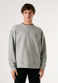 Felpa grigia in cotone con polsini e orlo a coste, presenta un logo ricamato bordeaux sul petto e una scollatura a girocollo con bordatura a contrasto.