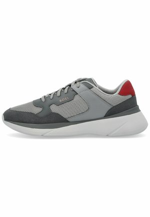 Grauer Sportschuh mit Netzpaneelen, Wildlederakzenten und einer weißen Sohle. Verfügt über eine rote Fersenschlaufe und ein metallisches Logo an der Seite.