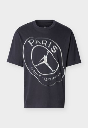 Sort kortærmet t-shirt med sølvfarvet Paris Saint-Germain-logo, der viser en basketballspiller i silhuet, der er i luften og holder en bold.