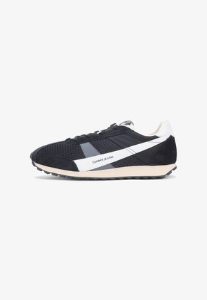 Svarta och grå sneakers med ovandel i mesh, mockaaccenter, vitt logotyp- och randmönster samt en texturerad gummisula.