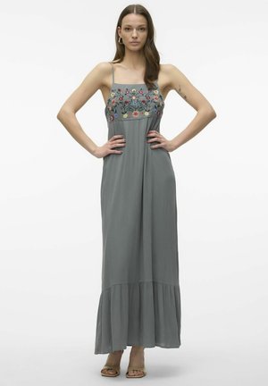 Maxiklänning i mjukt grått tyg med blommönster på bodice, spaghettiremmar och ett utsvängd slut. Slät textur och flödande design.