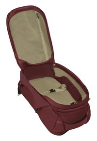 Sac de sport bordeaux avec une ouverture zippée, doublure intérieure beige, sangles réglables et compartiment en mesh pour l'organisation.