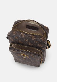 Sac bandoulière à motifs marron avec quincaillerie dorée, poches zippées doubles et logo de la marque. Le matériau semble texturé et durable.