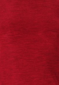 Närbild av ett rött strukturerat tyg med fina horisontella linjer och subtila färgvariationer.