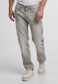 Jeans grigi chiaro realizzati in un tessuto misto cotone, caratterizzati da una vestibilità dritta, leggere sfumature, tasche frontali e una chiusura a bottone classica.