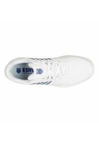 Zapatilla deportiva blanca con parte superior texturizada, rayas azules y cierre de cordones. Cuenta con suela acolchada y marca K-Swiss en el interior.