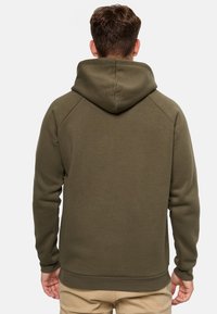 Olivengrøn hoodie har en stor hætte, raglanærmer og ribbede manchetter og kant. Glat stof med en behagelig pasform, bagfra vist.