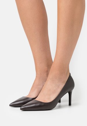 Tacchi alti in pelle nera con punta affusolata e un tacco a stiletto snodato di 7 cm. Texture liscia, design minimalista e senza motivi visibili.