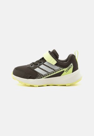 Sort og neongul Adidas Terrex børnesneaker med refleksstriber, velcrorem og tekstureret sål til udendørs aktiviteter.