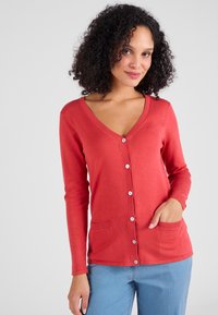 Rode lange mouwen cardigan met een V-hals, voorzien van knoopsluiting en twee voorklauwen. Gemaakt van een soepele, lichtgewicht stof.