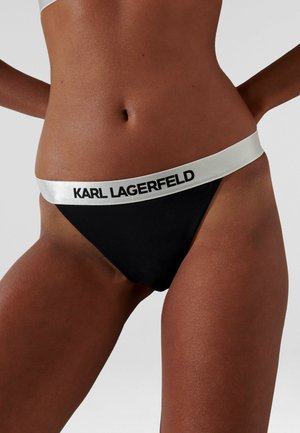 Zwarte bikini slip met een glanzende zilveren tailleband waarop "KARL LAGERFELD" in zwarte tekst staat. Glad materiaal, minimalistisch ontwerp.