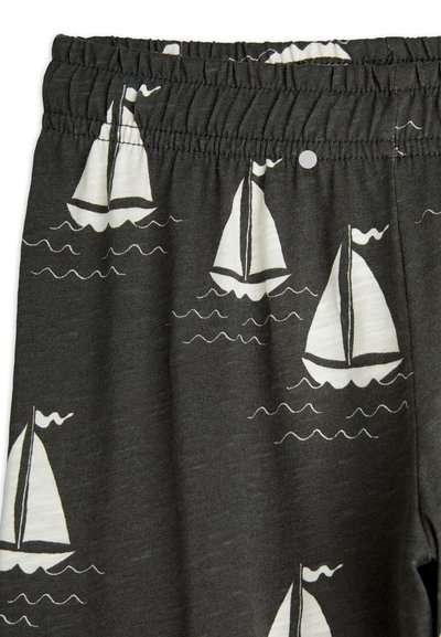 Gray fabric featuring a repeated sailboat pattern in white. Elastic waistband with subtle texture and stitched detailing.