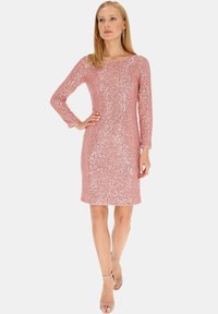 Różowa sukienka z cekinami, z długimi rękawami, dopasowanym krojem i okrągłym dekoltem. Gładka tekstura, długość do kolan z subtelnymi detalami w postaci błysku.