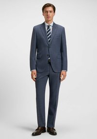 Navyblauw pak met een subtiele ruitpatroon, enkelvoudige knoopsluiting, notch revers, twee voorzakken, gecombineerd met een lichtblauw overhemd en een gestreepte stropdas.
