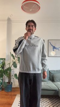 Hall halli pusakaga jakk, millel on mustad külgtriibud ja "GETS FRANS" tekst. Lahtine lõige, kantud mustade pükstega. Siseõhustik.