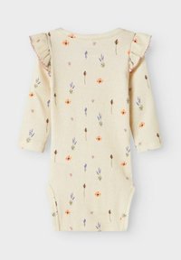 Rippstrick Langarm-Body in hellgelb, mit einem floralen Muster aus orange, lavendel und rosa Blumen; mit Rüschen an den Schultern.