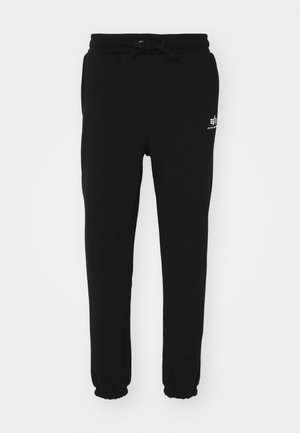 Black sweatpants made of soft fabric, featuring an elastic waistband with drawstring and ribbed cuffs. A small white logo is visible.