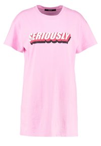 Růžové bavlněné tričko s krátkými rukávy a kulatým výstřihem. Na přední straně je výrazný nápis "SERIOUSLY" v bílé a červené barvě, který kontrastuje se pozadím.