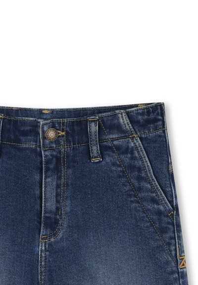 Jean en denim bleu foncé avec un design à cinq poches, couture visible et un bouton en métal à la taille. Texture lisse et coupe standard.