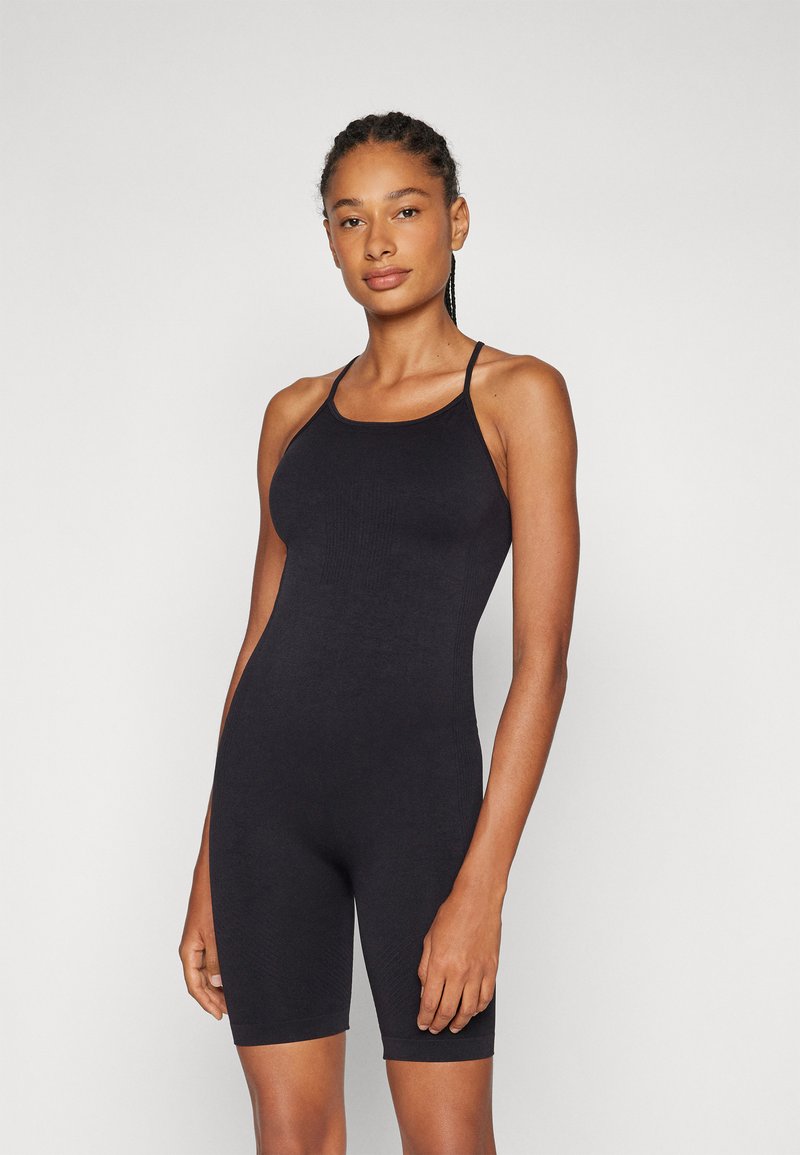 Svart bodysuit med tynne stropper, tettsittende design, midt på låret lengde, og ribbestruktur, uten synlige mønstre eller aksenter.