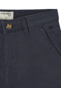 Pantalones infantiles azul marino hechos de algodón trenzado, con un botón en la parte delantera, cremallera y costuras de acento. Incluye dos bolsillos laterales y una etiqueta de marca.