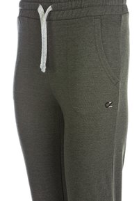 Mörkgröna sweatpants tillverkade av mjukt material, med en dragsnörning i en ljusare nyans, sidofickor och en liten logotyp på låret.