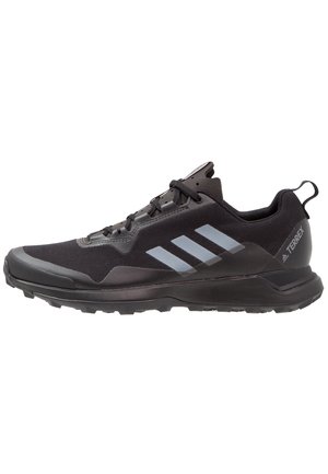 Baskets de trail running Adidas Terrex noires avec des rayures grises, fermeture à lacets et semelle texturée pour terrains extérieurs.