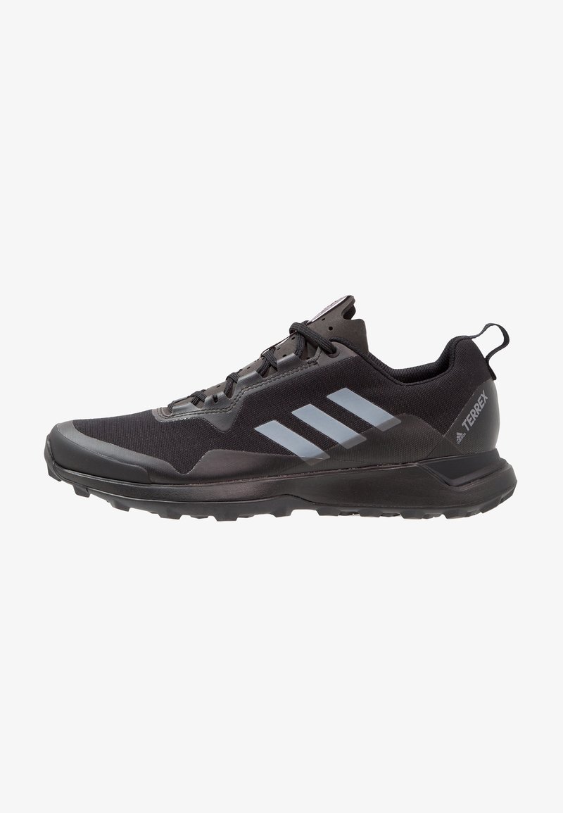 Baskets de trail running Adidas Terrex noires avec des rayures grises, fermeture à lacets et semelle texturée pour terrains extérieurs.