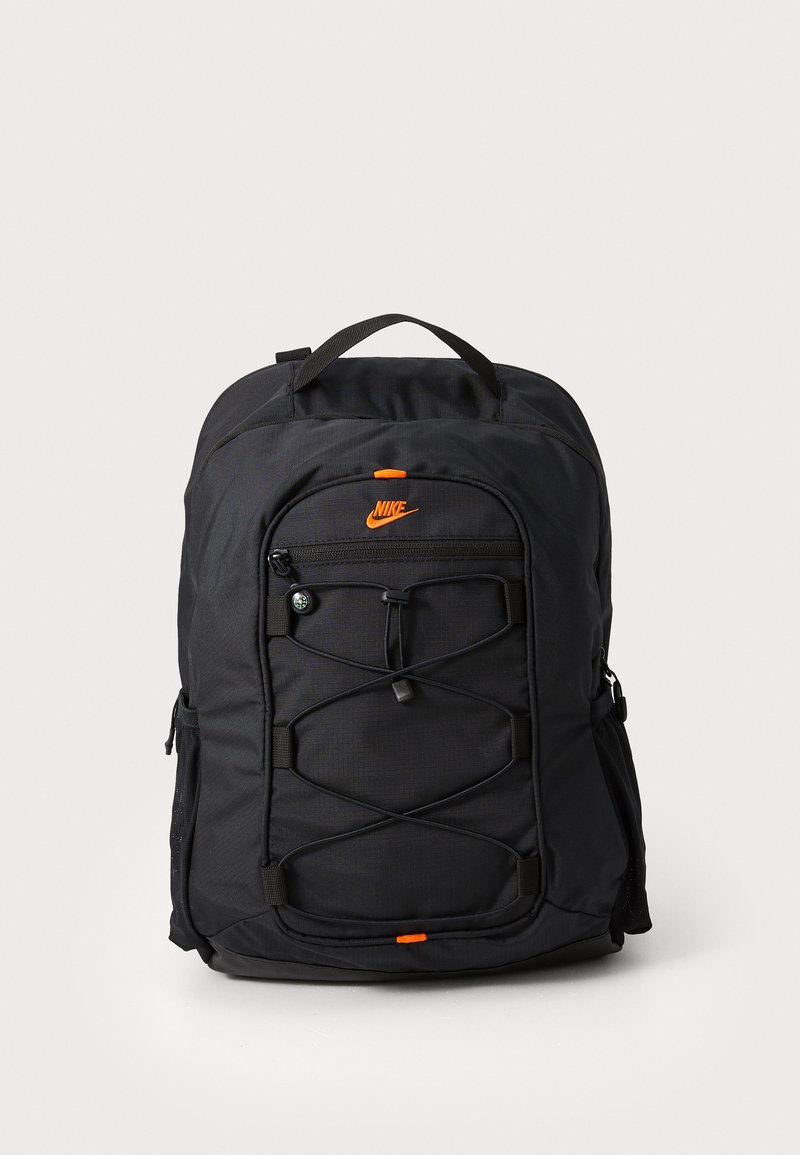 Melna neilona mugursoma ar priekšējo rāvējslēdzēju, ar aukliņu aizdari un oranžiem akcentiem. Aprīkota ar regulējamiem siksnām un sietveida sānu kabatām.