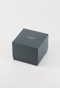 Tmavě modrá čtvercová krabička s hladkým povrchem, na víku vytištěným bílým nápisem "TIMEX", určena k balení hodinek nebo doplňku.