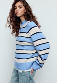Maglione a righe con colori azzurro chiaro, crema e blu navy. Presenta una scollatura e polsini a coste, con una vestibilità comoda e un tessuto strutturato.