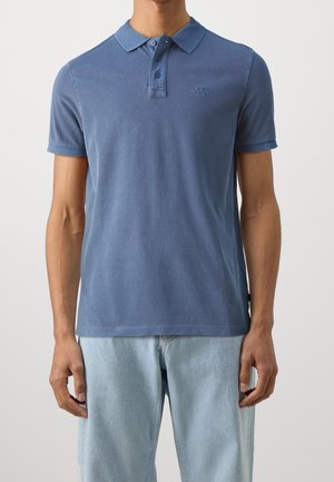 Polo en coton bleu clair. Dispose d'un col classique, d'une patte à trois boutons et d'un logo discret sur la poitrine. Coupe régulière.