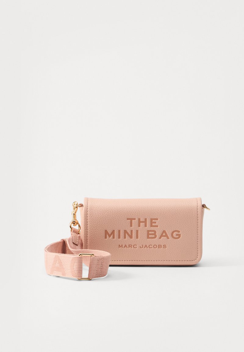 Mini kott pehmest roosast tekstuuriga nahast, kullatud detailidega, millel on trükitud tekst "THE MINI BAG" ja eemaldatav kangast rihm.