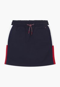 Gonna sportiva blu navy con vita elastica, con strisce laterali bianche e rosse e coulisse. Morbido cotone.