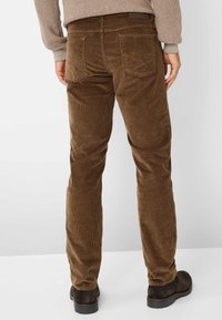 Pantaloni in corduroy marrone con righe verticali, gamba dritta e due tasche posteriori. Abbinati a calzature scure, mostrati da dietro.