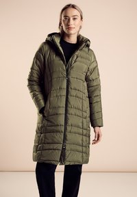 Olchowo-zielony, pikowany długi płaszcz z zamkiem błyskawicznym z przodu, kapturem i kieszeniami po bokach. Gładka tekstura i luźny krój, z poziomymi przeszyciami.