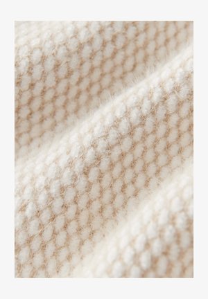 Close-up van zachte beige en witte gebreide stof met een gestructureerd patroon van afwisselend verhoogde en platte horizontale banen.