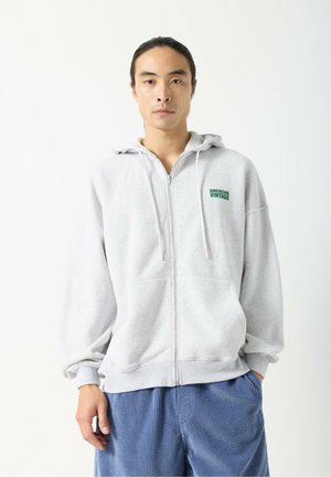 Hall hall zip-up dressipluus kapuutsiga ja rohelise "American Vintage" logoga. Omaduseks mugav lõige ja pehme, tekstuuriga kangas.