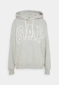Felpa grigia chiara con un grande logo "GAP" bianco contornato sul petto e i cordini color crema sul cappuccio.