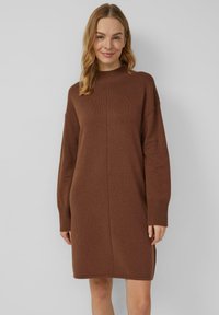 Braunes, gestricktes Kleid mit hohem Kragen, langen Ärmeln und gerippten Bündchen. Es hat einen geraden Schnitt mit einer zentralen Naht auf der Vorderseite.