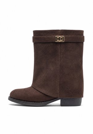 Brauner Wildleder-Stiefel bis zur Mitte der Wade mit niedrigem Absatz, rundem Zeh, umlaufendem Riemen und goldener rechteckiger Schnalle auf weißem Hintergrund.