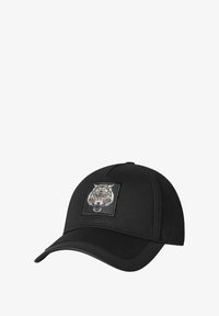 Gorra negra con visera redondeada y parte superior plana, que presenta un diseño de tigre bordado en un parche negro. Textura de tela suave.