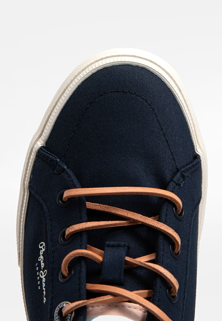 Navy-Canvas-Sneaker mit beiger Gummisohle. Verfügt über braune Schnürsenkel und Metallösen. Logo auf der Seite sichtbar. Abgerundete Zehenform.
