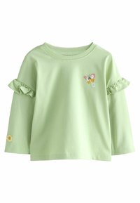 Chemise à manches longues vert clair avec des manches à volants. Présente des détails brodés de papillons et de fleurs. Matériau en coton doux.