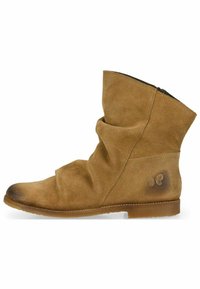 Stivaletto in suede marrone con design a sbuffo, suola piatta e dettaglio del logo a farfalla sul tallone. Finitura testurizzata e leggero gradiente di colore.