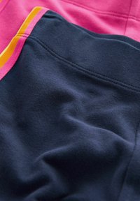 Tessuto blu navy con una superficie liscia e cuciture accentuate in rosa e giallo. Le sezioni sovrapposte creano un aspetto stratificato.
