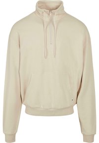 Kremfarget genser med halv-zip krage, lange ermer, ribbestrikkede mansjetter og en frontkangaroo lomme. Myk stoff, avslappet passform.