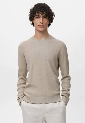 Pull en tricot côtelé beige avec un col rond et des manches longues. Présente une taille ajustée et un motif texturé sur l'ensemble.